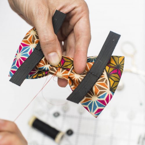 Dog bow attaches to collars with hook and loop tape.